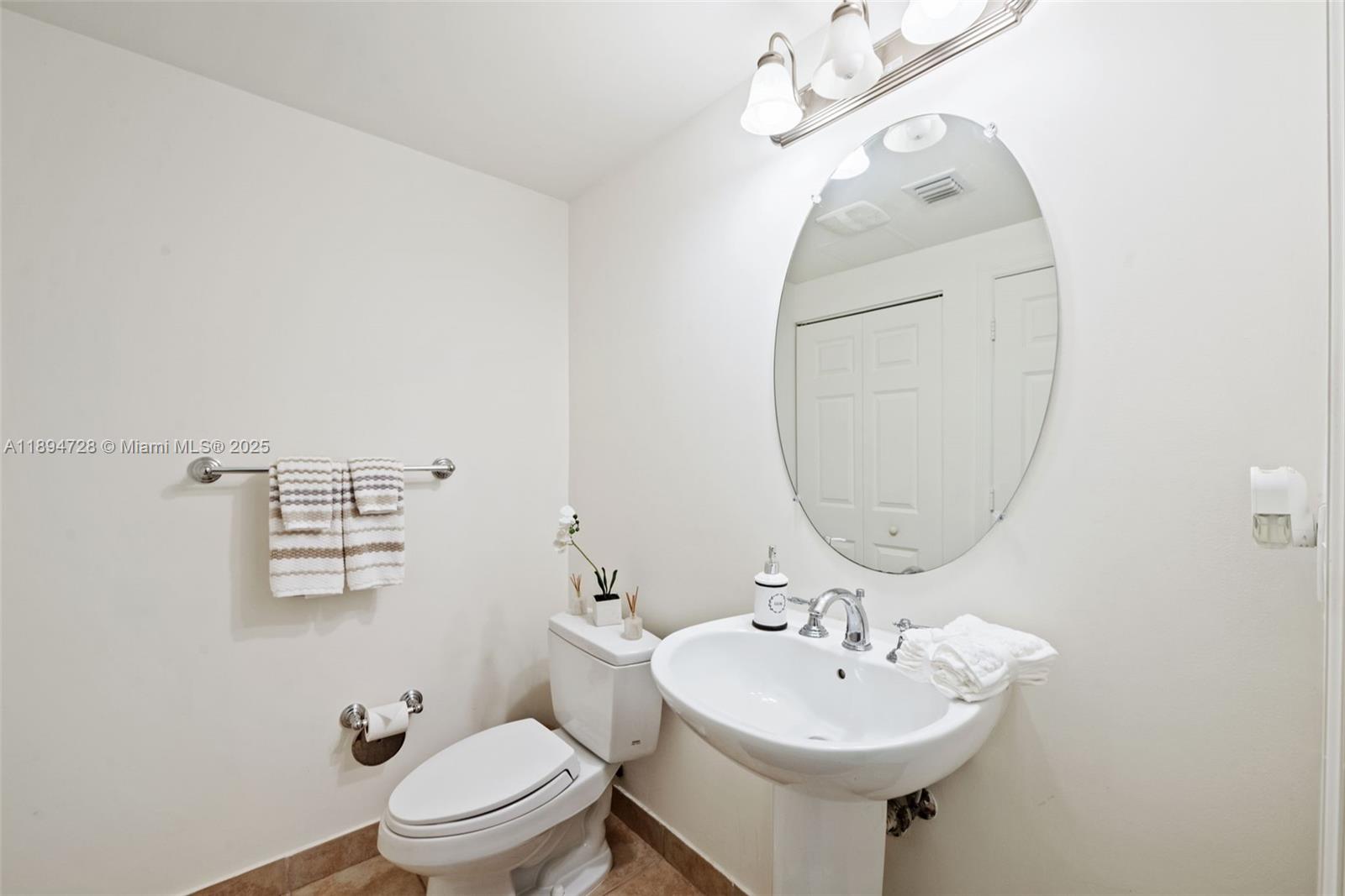 888 Douglas Road, Unit 113 Coral Gables, FL 33134 - Photo 21 of 40 a bathroom with a sink a mirror and toilet