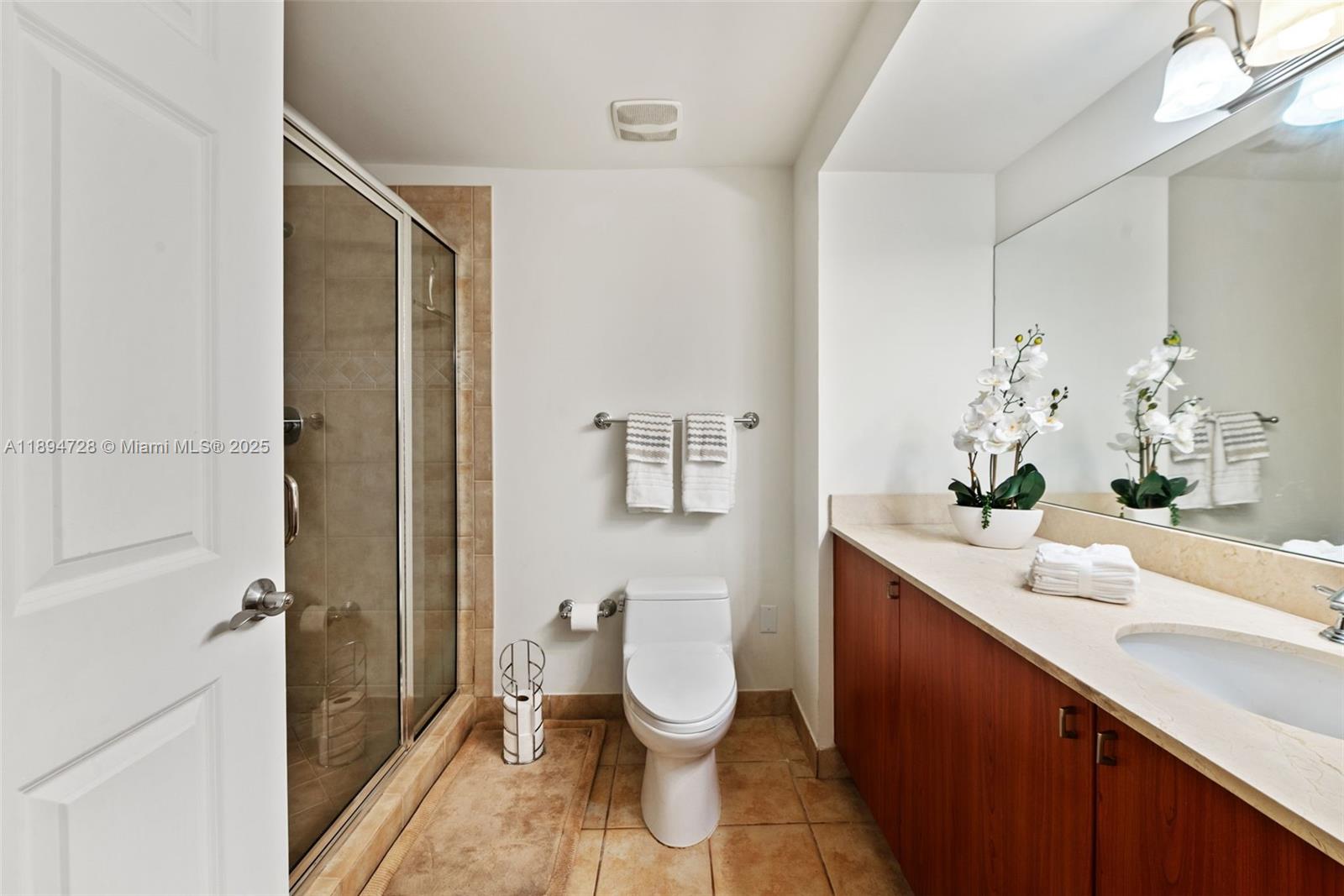 888 Douglas Road, Unit 113 Coral Gables, FL 33134 - Photo 28 of 40 a bathroom with a toilet sink and mirror