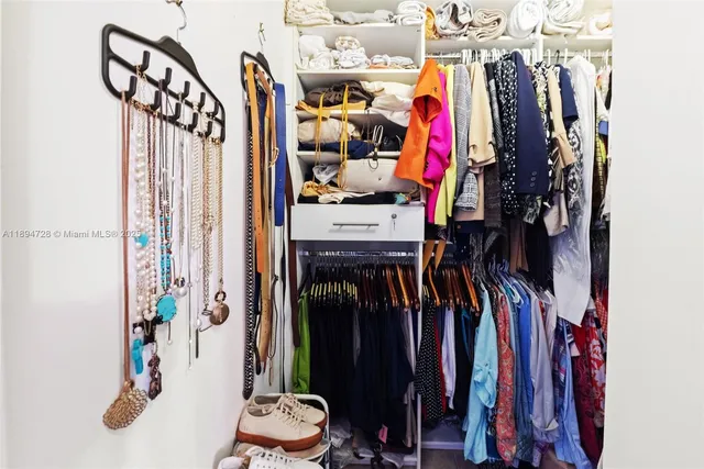 a view of walk in closet with clothes