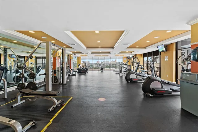 a gym room with gym equipment and a large window