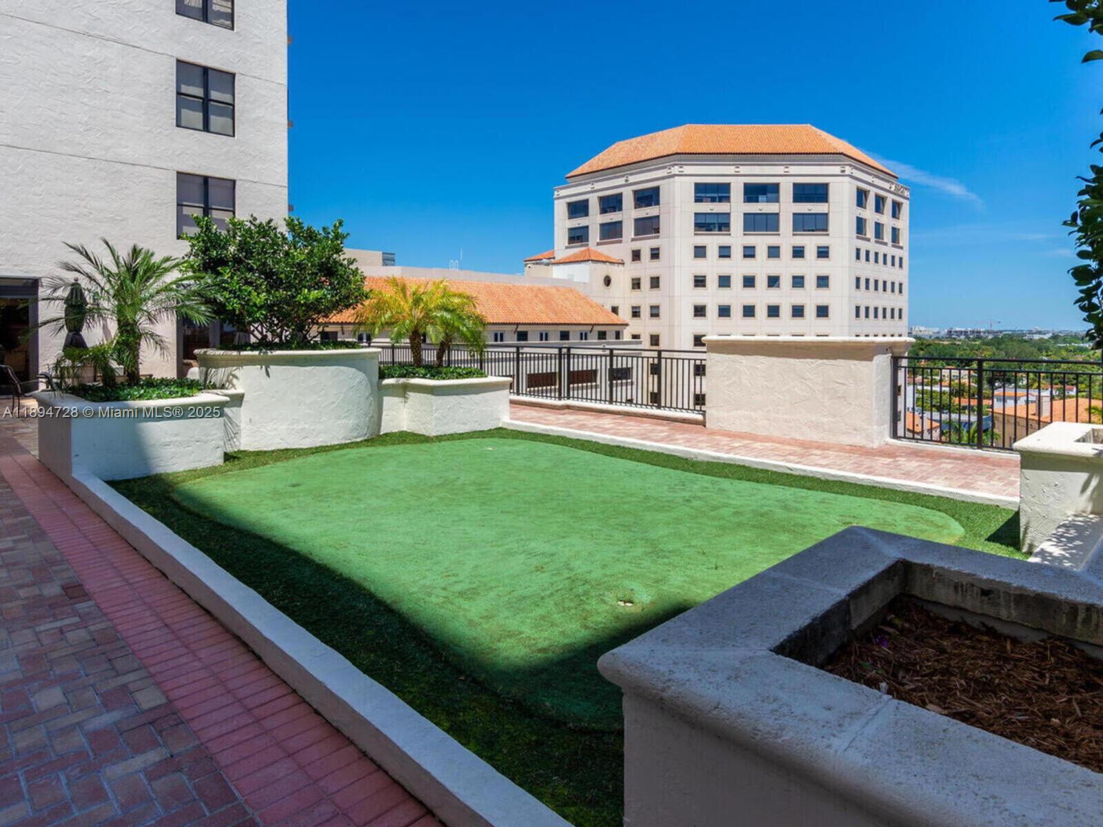 888 Douglas Road, Unit 113 Coral Gables, FL 33134 - Photo 37 of 40 a front view of a house with garden
