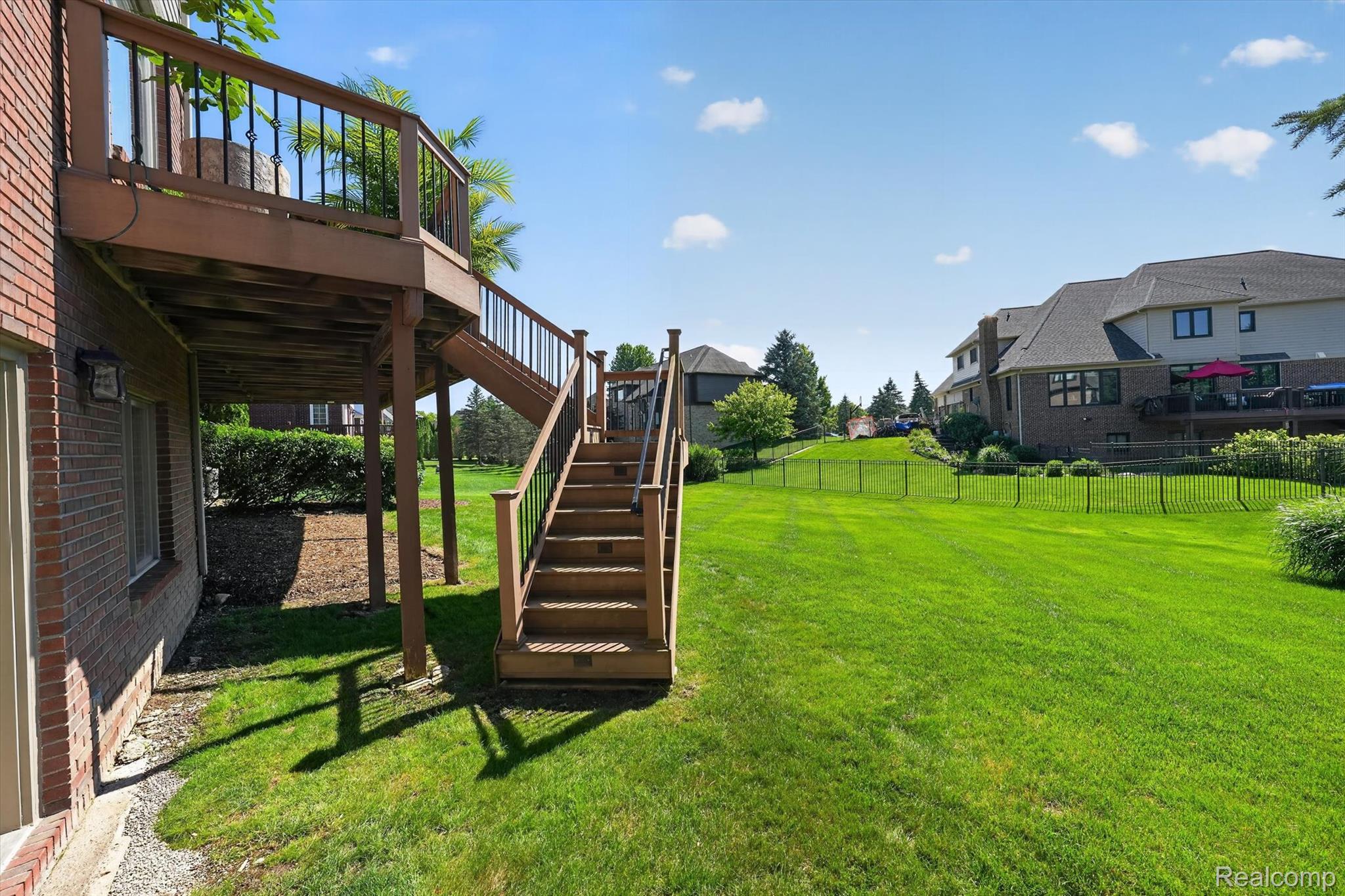 3804 Elk Drive Rochester, MI 48306 - Photo 53 of 75 Multi-level composite deck with baluster railing accessed from the kitchen, offering direct access to a sprawling green lawn