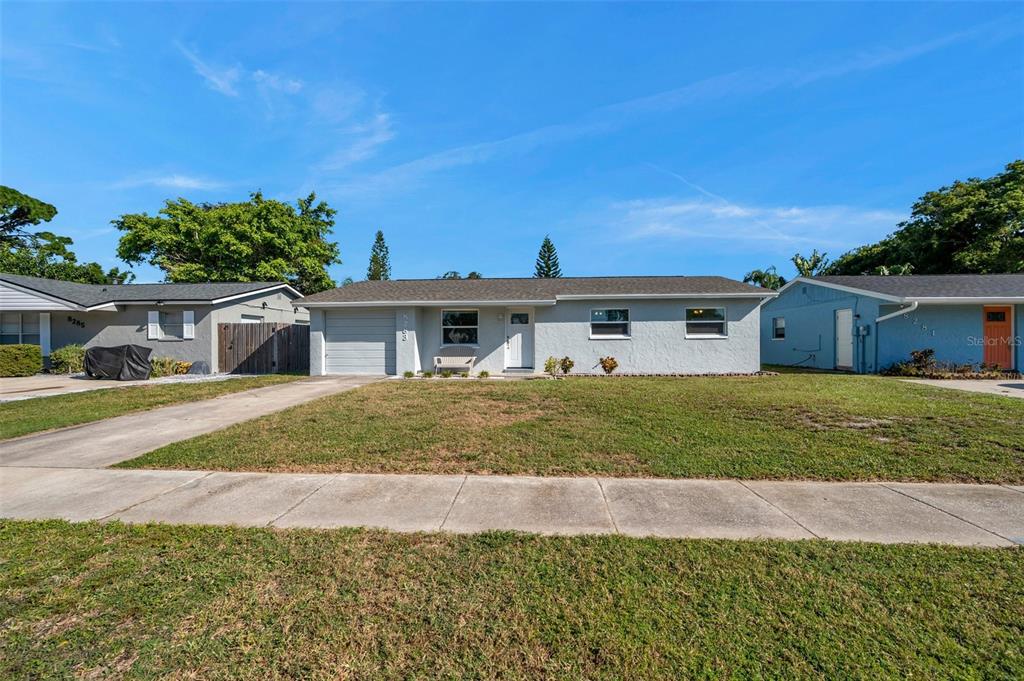 8283 86th Avenue North Seminole, FL 33777 - Photo 1 of 58 a front view of a house with a garden