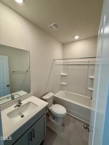 a bathroom with a sink mirror vanity and toilet