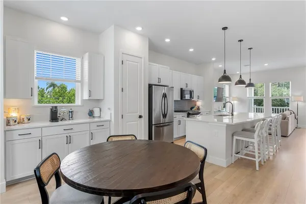 a kitchen with refrigerator a sink and chairs