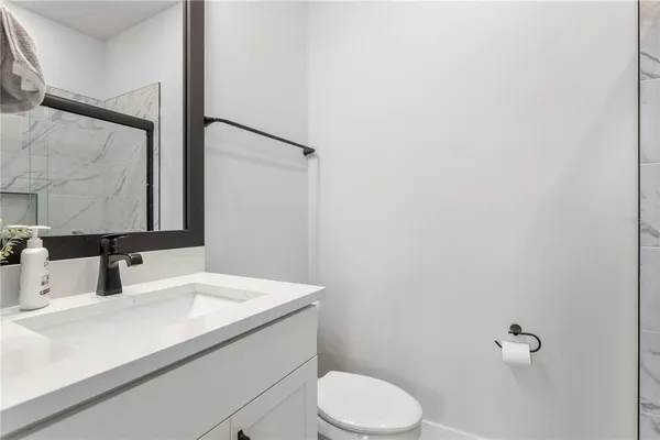 a bathroom with a sink a toilet and mirror