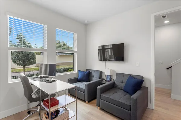 a living room with furniture a flat screen tv and a large window