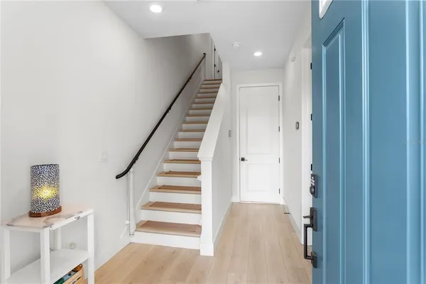 a view of a hallway with entryway wooden floor and front door