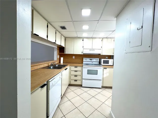 a kitchen with cabinets stainless steel appliances and a window