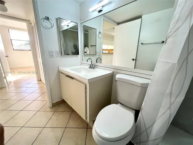 a white toilet sitting next to a bathroom sink