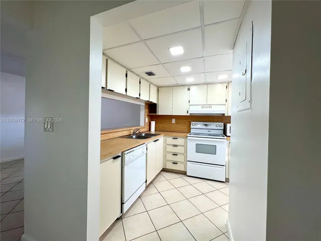 a kitchen with white cabinets and white appliances