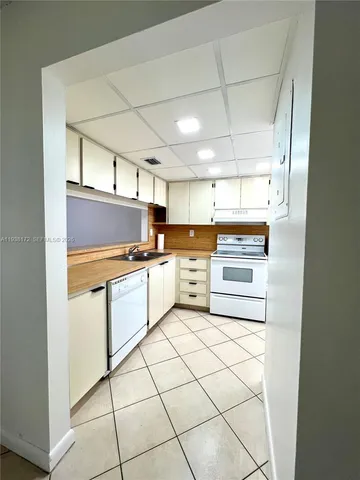 a kitchen with white cabinets and white appliances