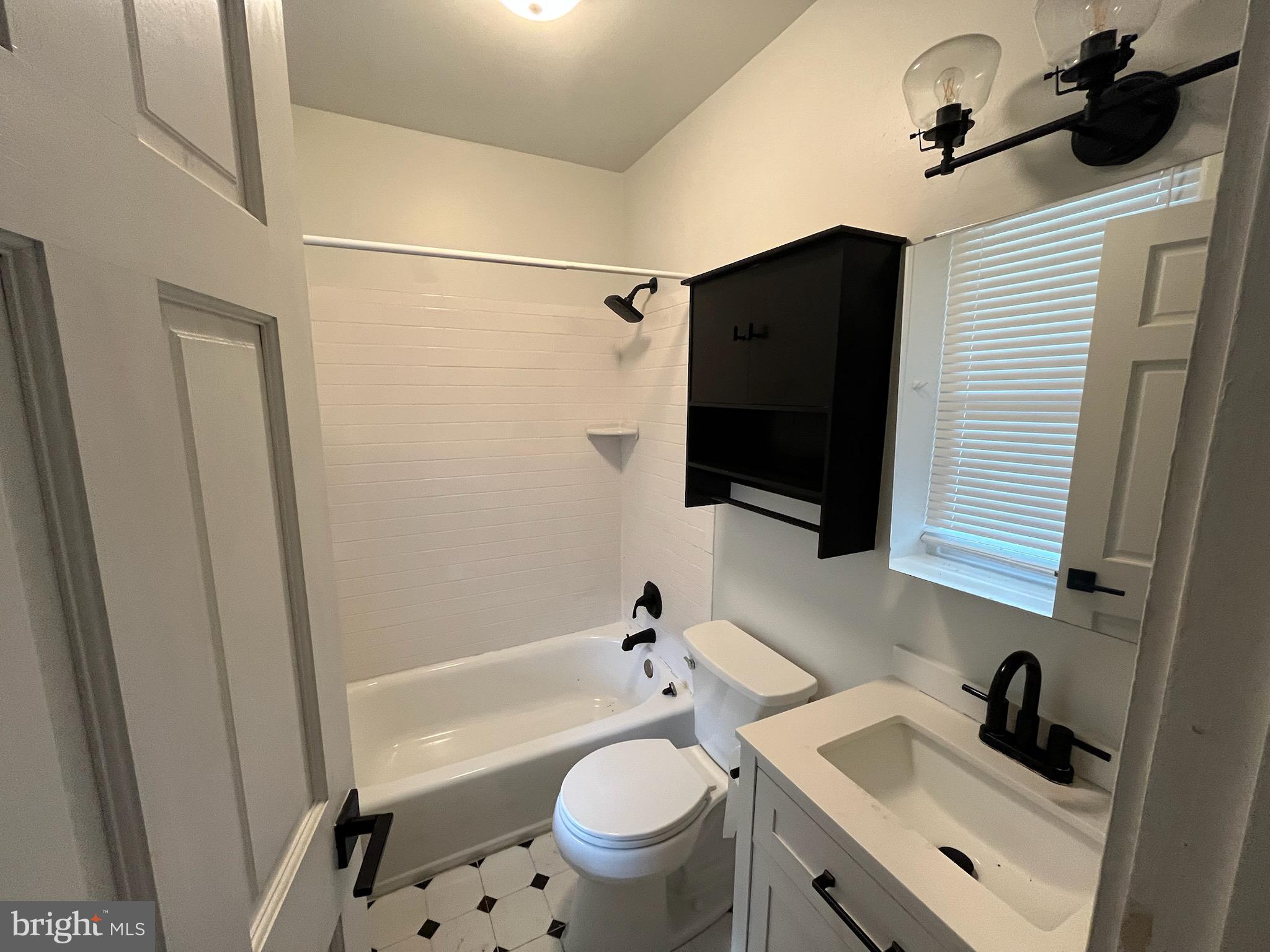 357 Lyceum Avenue, Unit A Philadelphia, PA 19128 - Photo 12 of 14 a bathroom with a sink a toilet a mirror and shower