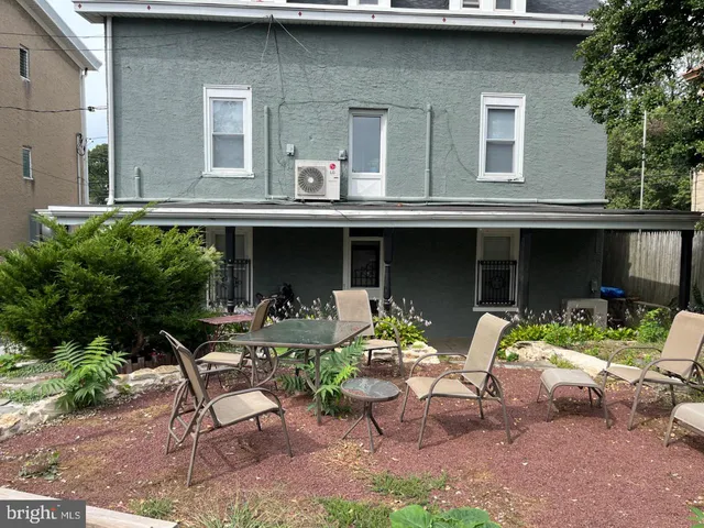 a view of a house with a backyard and sitting area