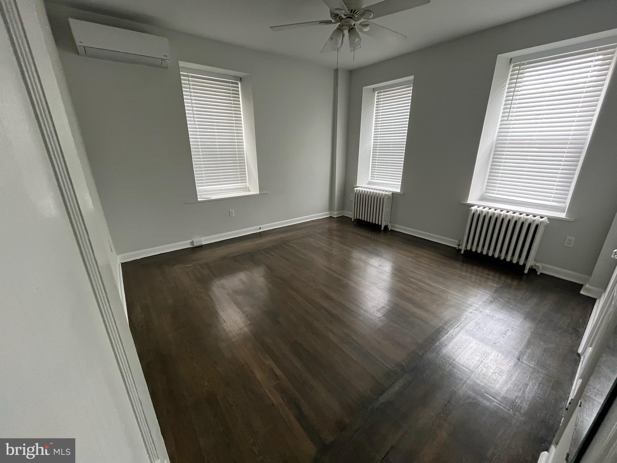 357 Lyceum Avenue, Unit A Philadelphia, PA 19128 - Photo 4 of 14 an empty room with wooden floor and windows