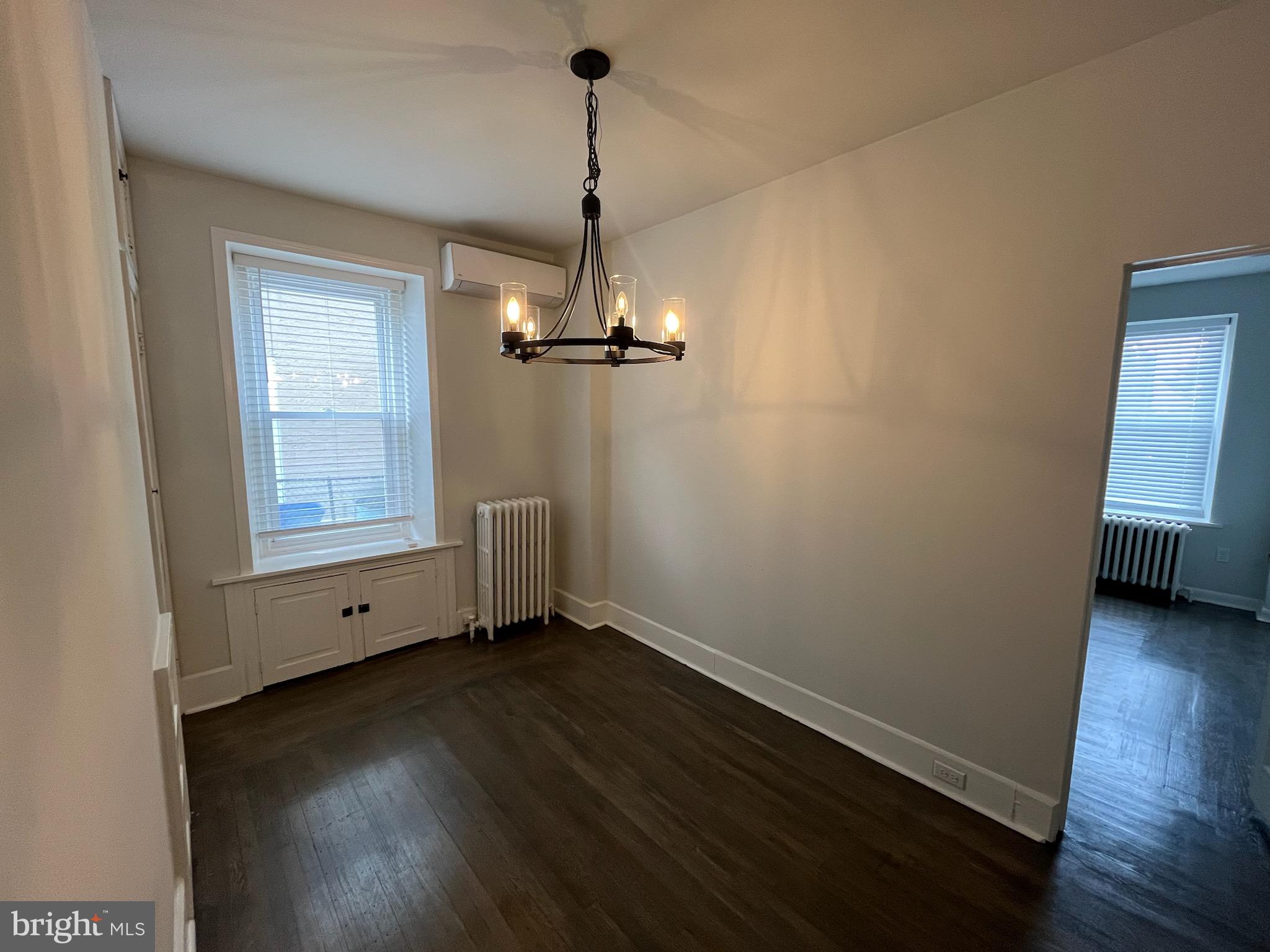 357 Lyceum Avenue, Unit A Philadelphia, PA 19128 - Photo 6 of 14 a view of an empty room with wooden floor and a window