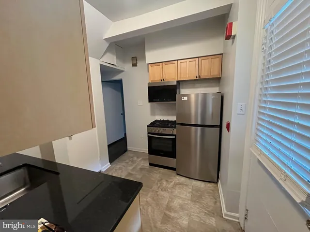 a kitchen with a refrigerator and a stove top oven