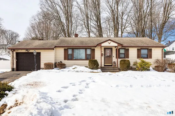 a front view of a house with a yard covered in snow