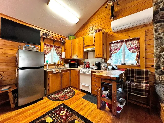 a kitchen with refrigerator a stove and a dining table
