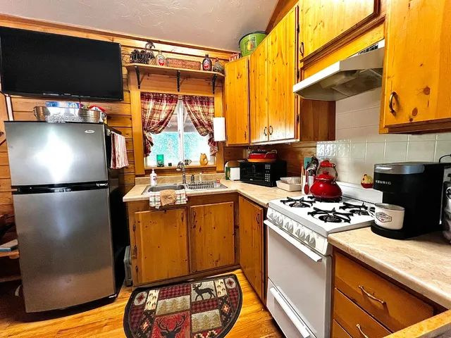 a kitchen with a refrigerator a stove and a microwave