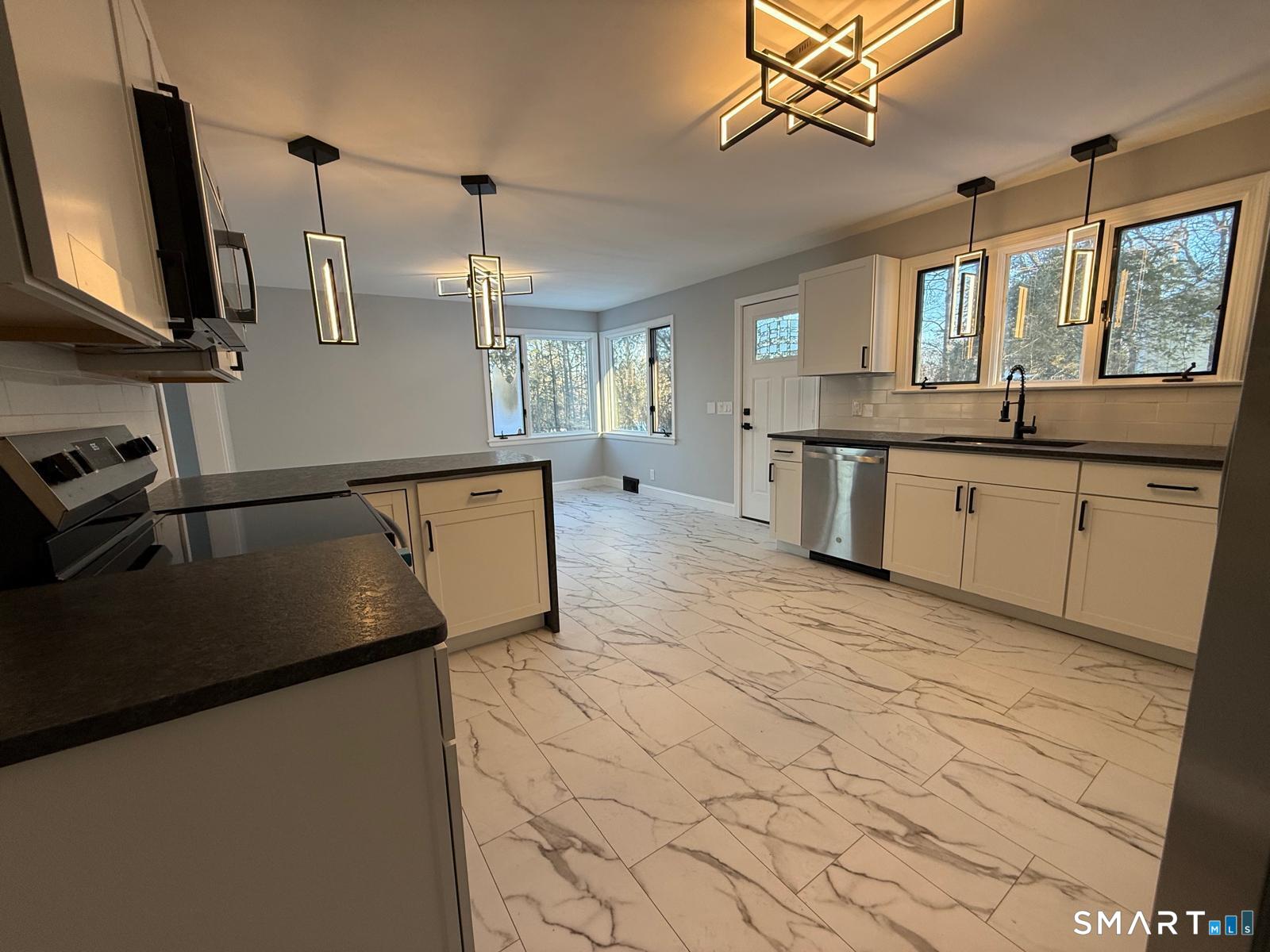 46 Bracewood Road Waterbury, CT 06706 - Photo 22 of 25 a kitchen with stainless steel appliances granite countertop a sink a stove top oven a counter space and cabinets