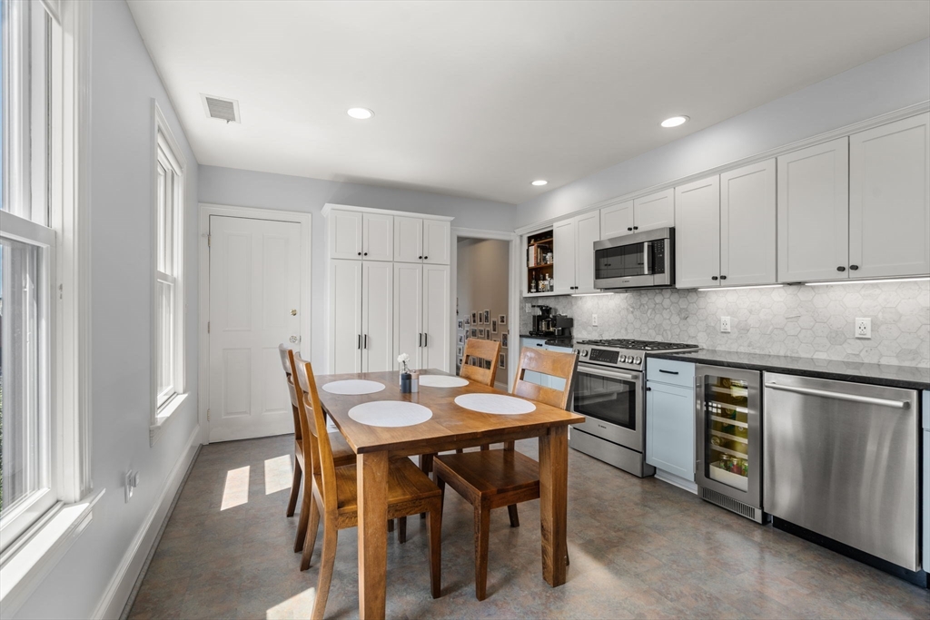 48 Mt Vernon Street, Unit 3 Boston, MA 02129 - Photo 9 of 31 a kitchen with stainless steel appliances granite countertop a stove a sink a microwave a dining table and chairs
