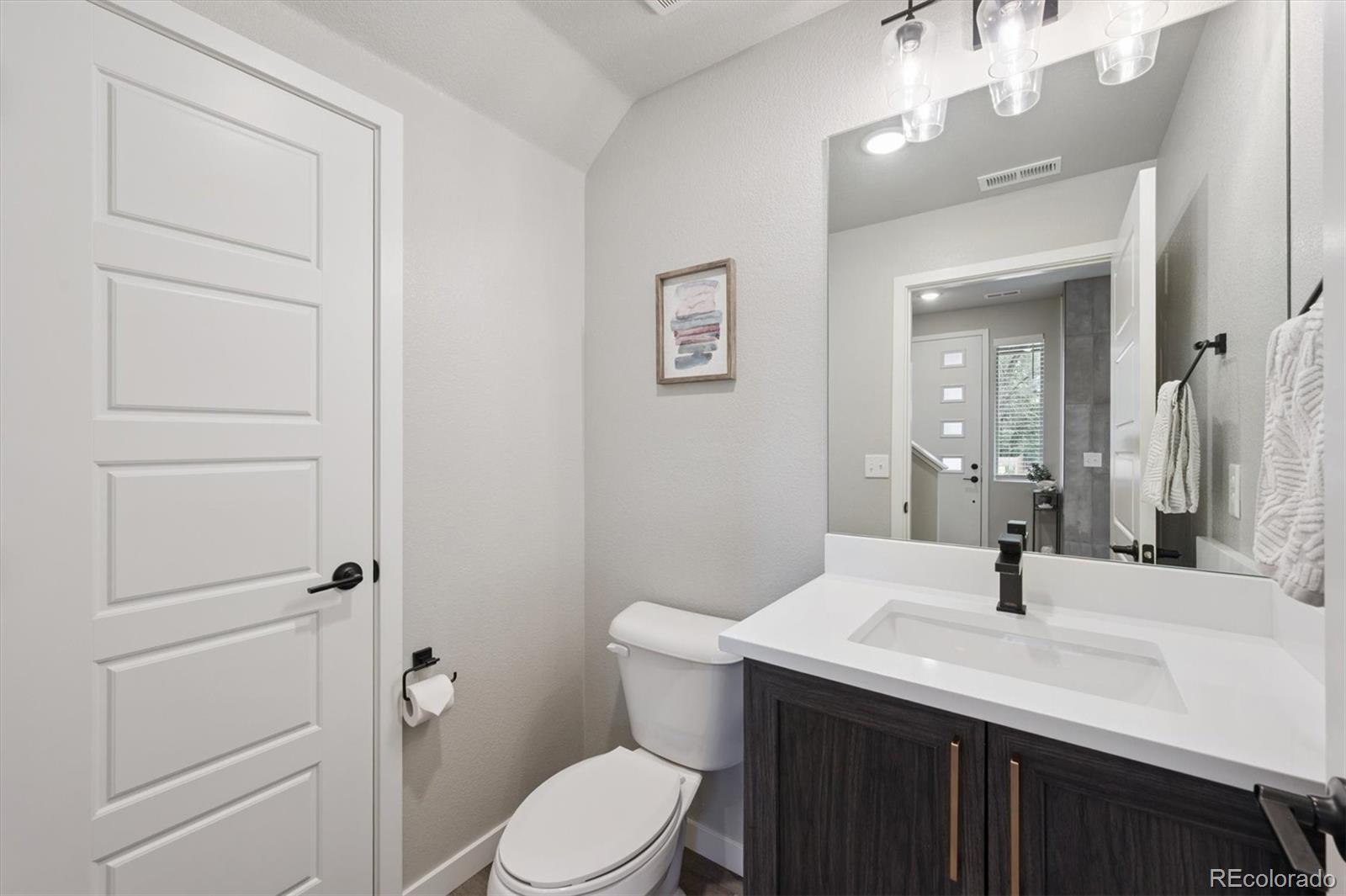 11772 West 45th Place Wheat Ridge, CO 80033 - Photo 14 of 25 a bathroom with a sink a toilet and mirror
