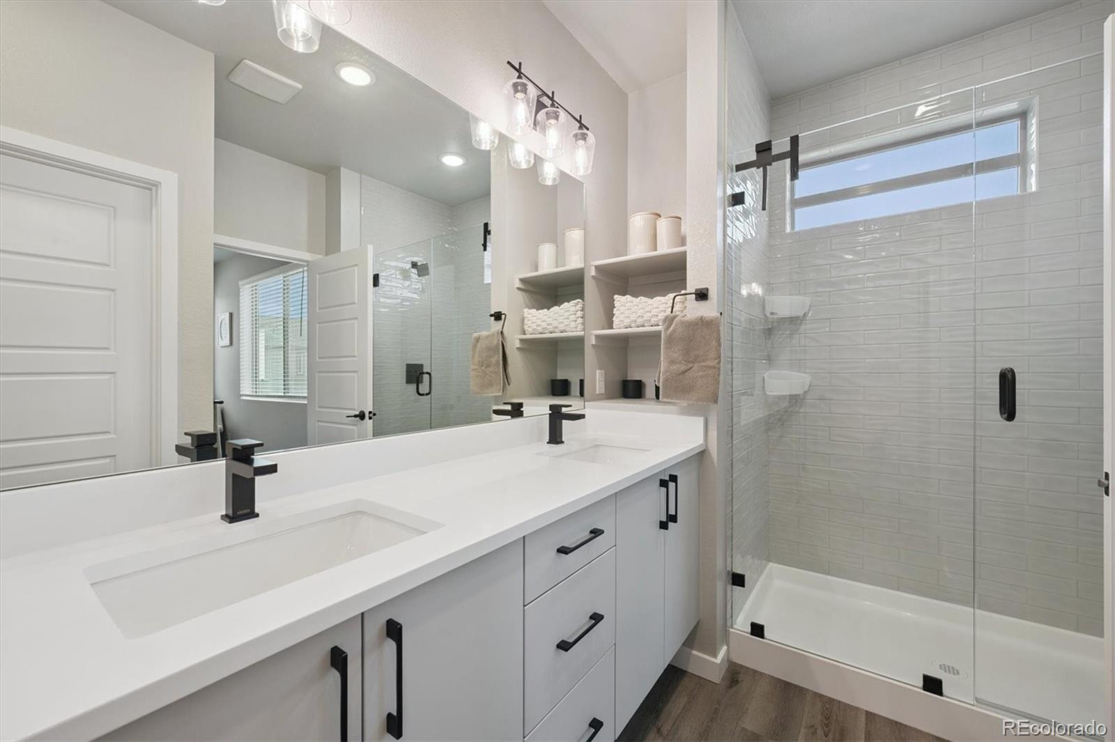 11772 West 45th Place Wheat Ridge, CO 80033 - Photo 17 of 25 a bathroom with a sink double vanity granite tub shower and a mirror