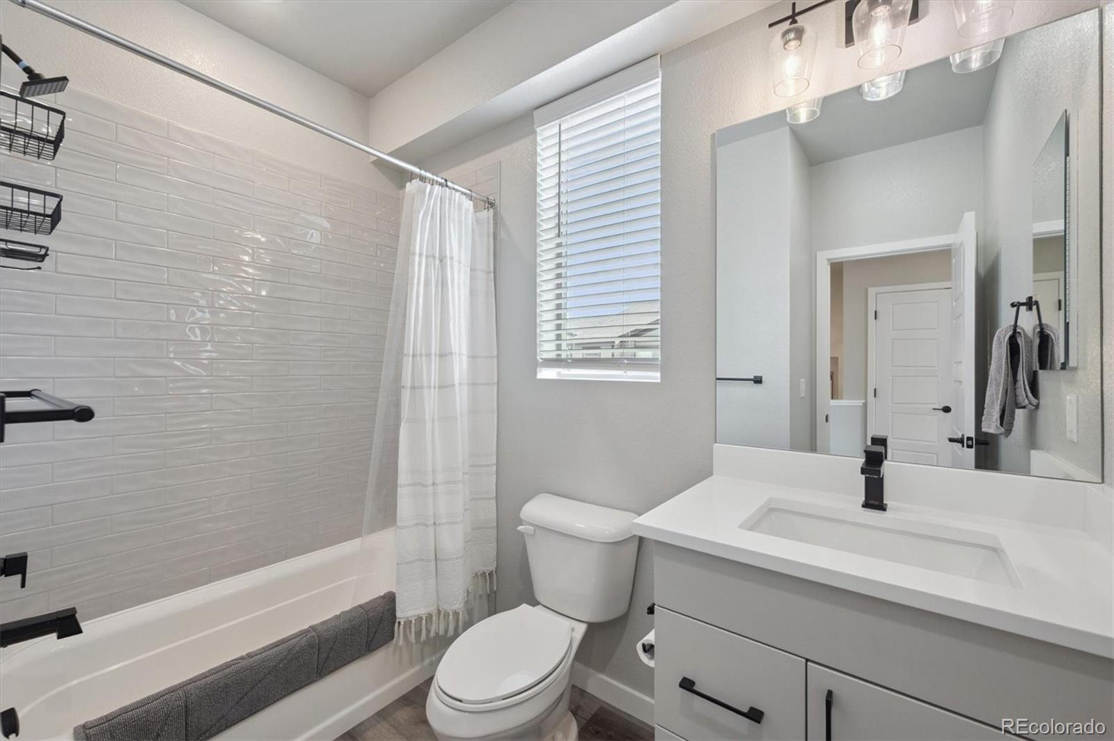 11772 West 45th Place Wheat Ridge, CO 80033 - Photo 19 of 25 a bathroom with a sink a toilet and shower