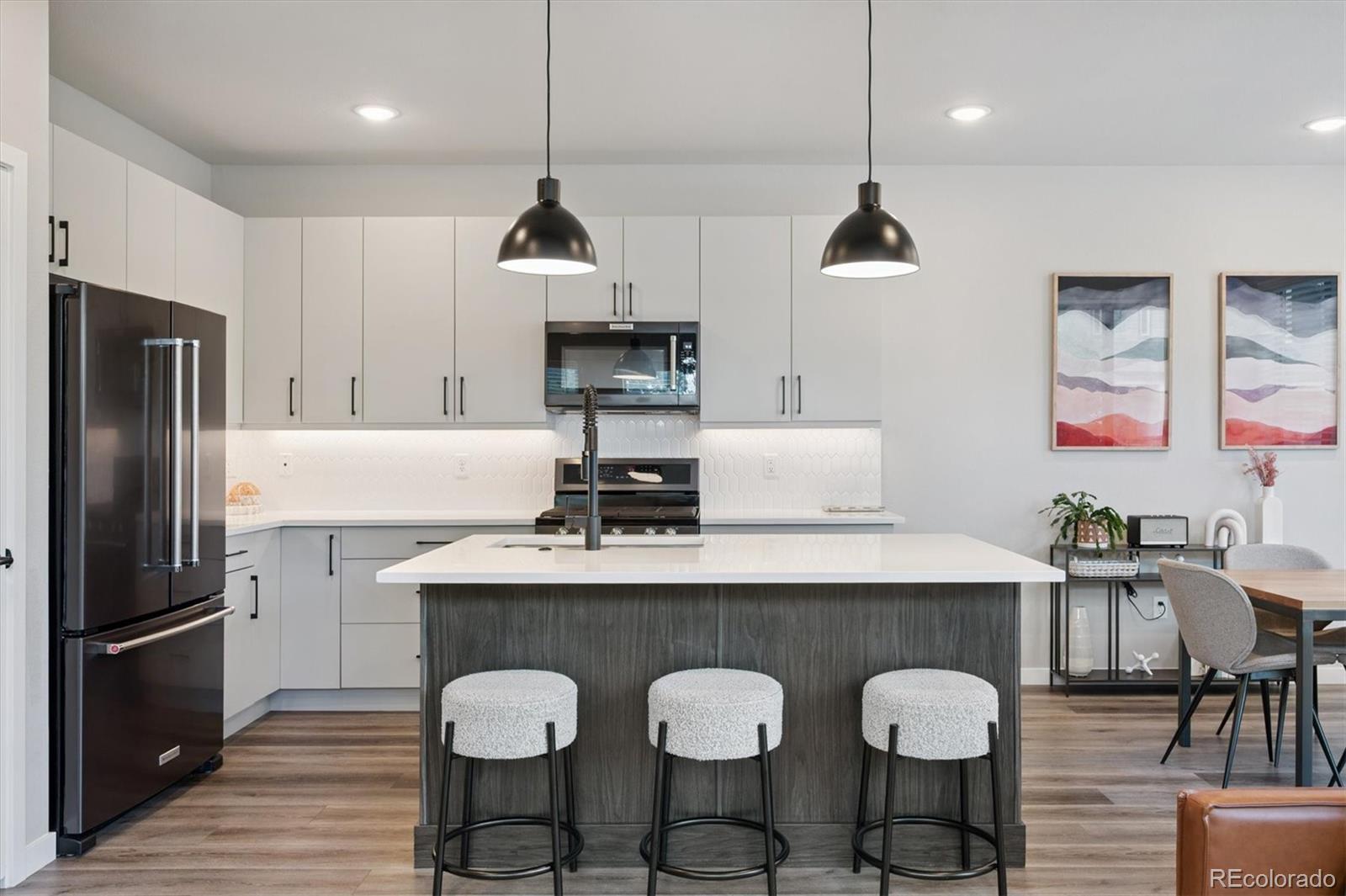 11772 West 45th Place Wheat Ridge, CO 80033 - Photo 5 of 25 a kitchen with granite countertop a table chairs stainless steel appliances and cabinets