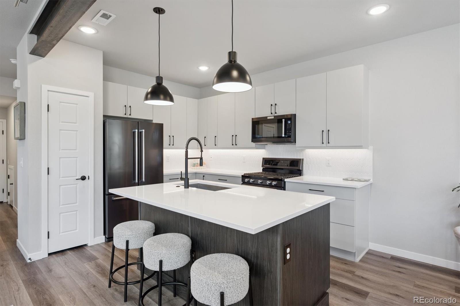 11772 West 45th Place Wheat Ridge, CO 80033 - Photo 7 of 25 a kitchen with sink cabinets and wooden floor