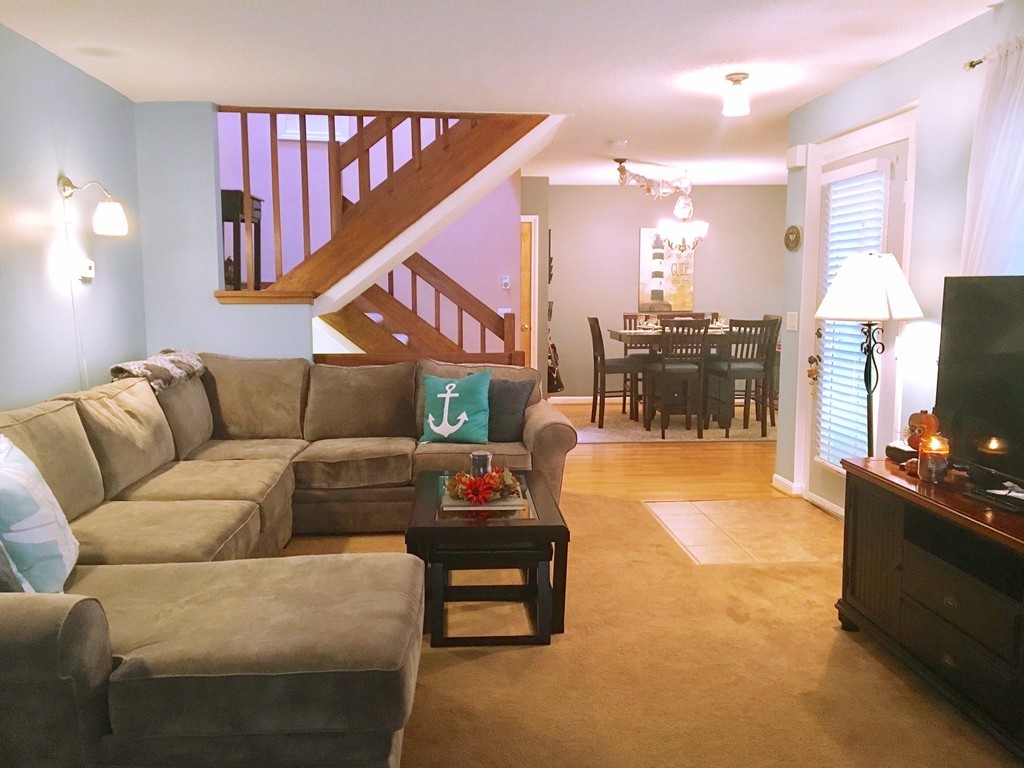 49 Captain Eames Circle, Unit 49 Ashland, MA 01721 - Photo 7 of 12 a living room with furniture a flat screen tv and a dining table