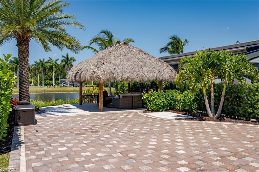 13461 Ladyfish Lane Naples, FL 34114 - Photo 14 of 30 a view of a backyard with potted plants and a palm tree