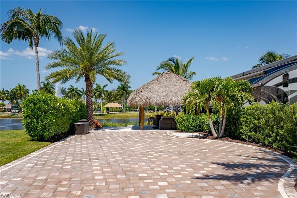 13461 Ladyfish Lane Naples, FL 34114 - Photo 17 of 30 a front view of a house with a yard and potted plants