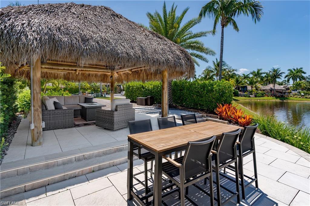13461 Ladyfish Lane Naples, FL 34114 - Photo 6 of 30 a view of a patio with table and chairs potted plants with palm tree