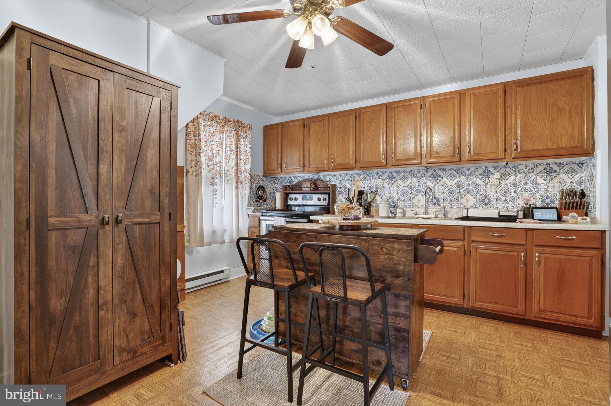 7278 Fleming Road New Church, VA 23415 - Photo 12 of 44 a kitchen with stainless steel appliances granite countertop wooden cabinets a dining table and chairs