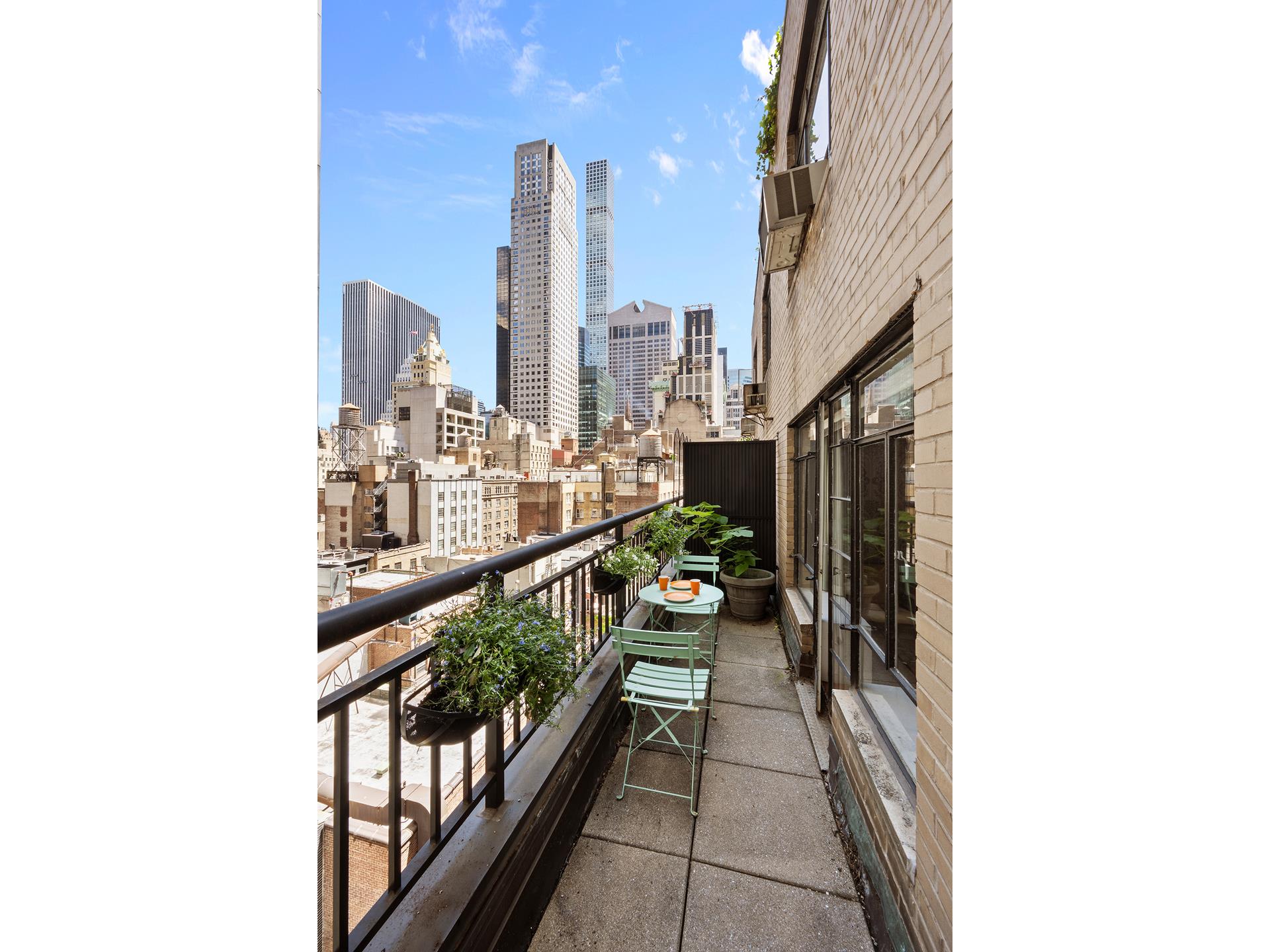 45 West 54th Street, Unit 11/12A Manhattan, NY 10019 - Photo 5 of 18 a view of a balcony with many windows and furniture