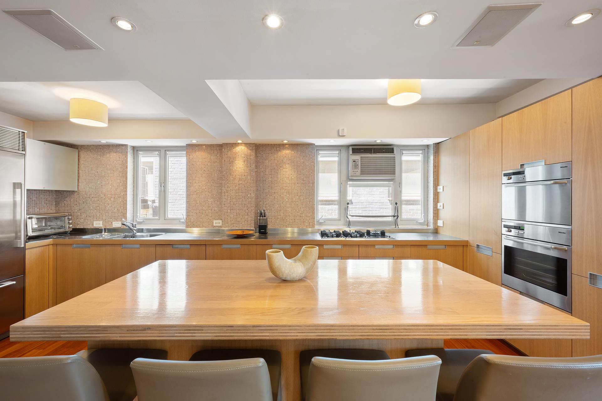 45 West 54th Street, Unit 11/12A Manhattan, NY 10019 - Photo 8 of 18 a view of a kitchen with kitchen island a large window