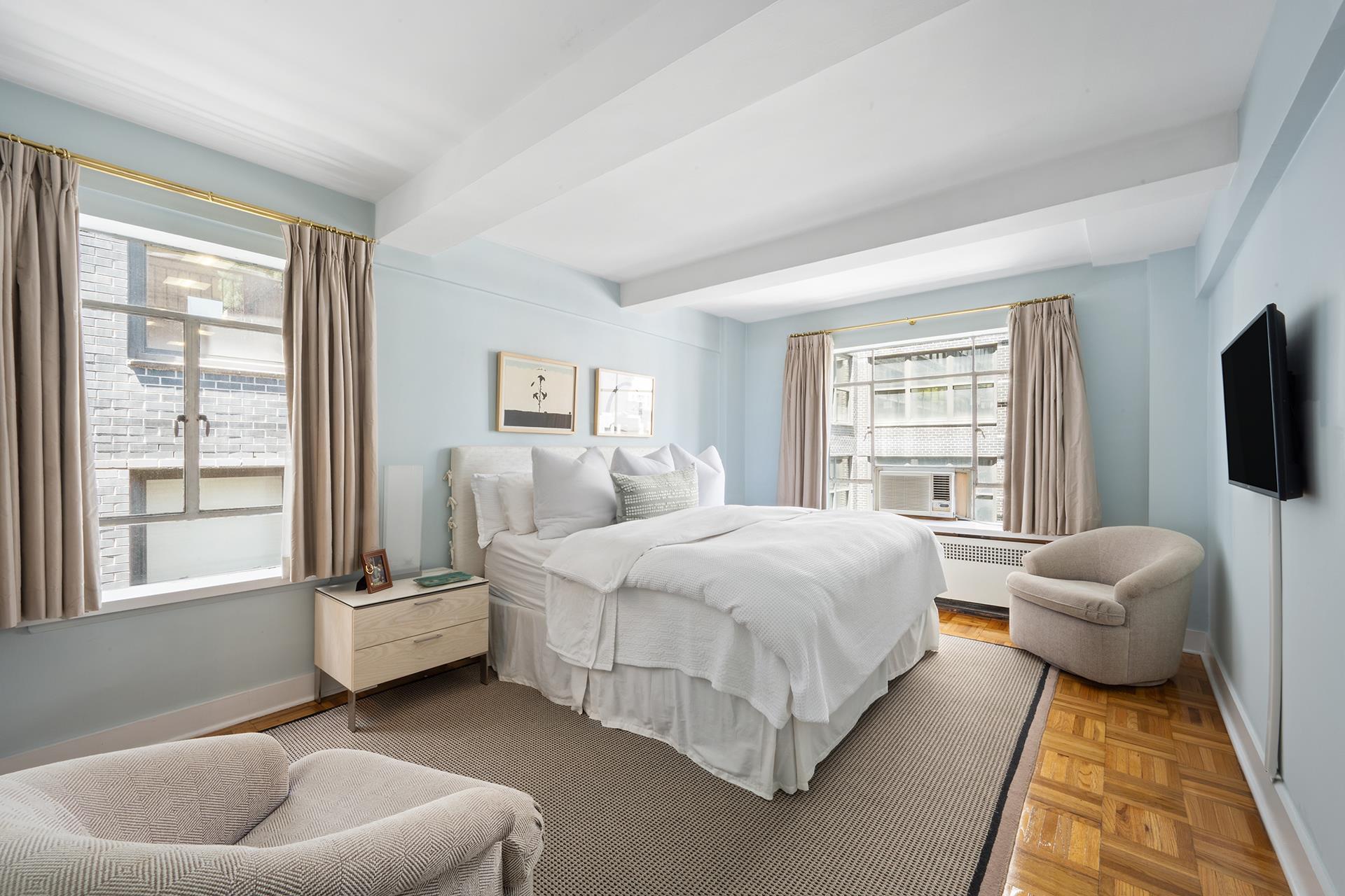 45 West 54th Street, Unit 11/12A Manhattan, NY 10019 - Photo 9 of 18 a spacious bedroom with a bed and glass window