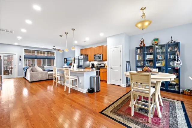 a living room with furniture and a dining table with kitchen view