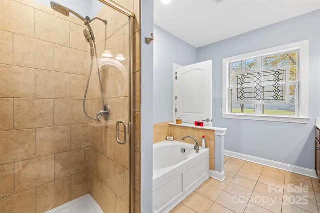 a bathroom with a bathtub a shower and a window