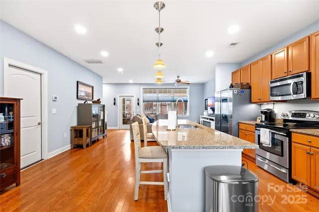 a large kitchen with stainless steel appliances granite countertop a stove and refrigerator