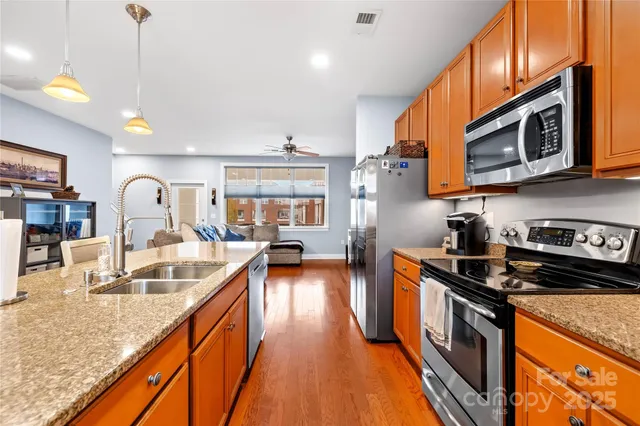 a kitchen with stainless steel appliances granite countertop a stove a sink and a microwave