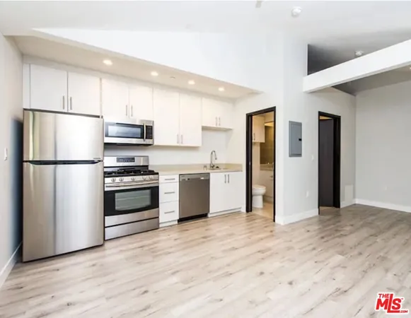 a kitchen with stainless steel appliances a refrigerator sink and cabinets