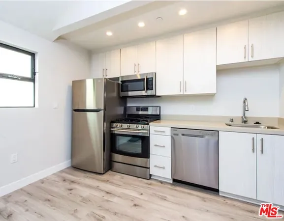 a kitchen with granite countertop a refrigerator and a sink