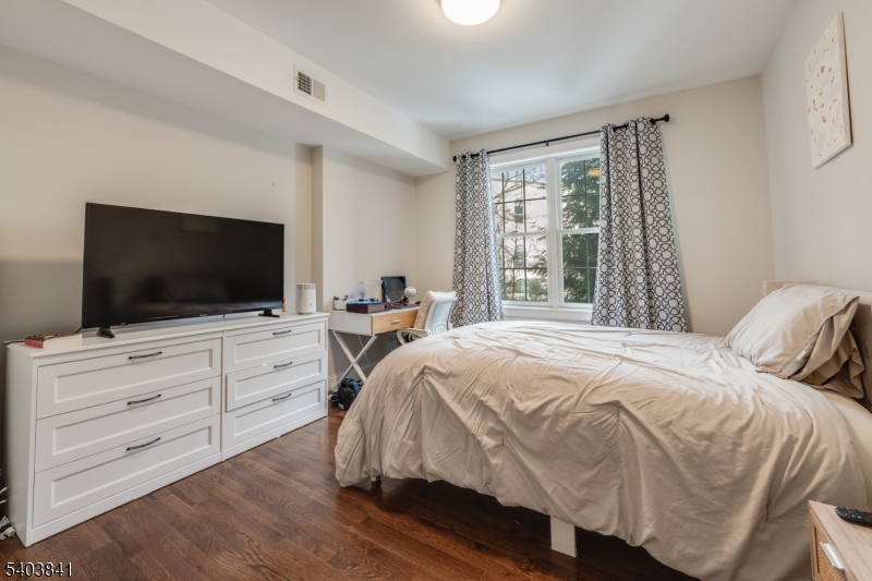 231 River Road, Unit 231 Somerville, NJ 08876 - Photo 22 of 31 a bedroom with a bed and a flat screen tv