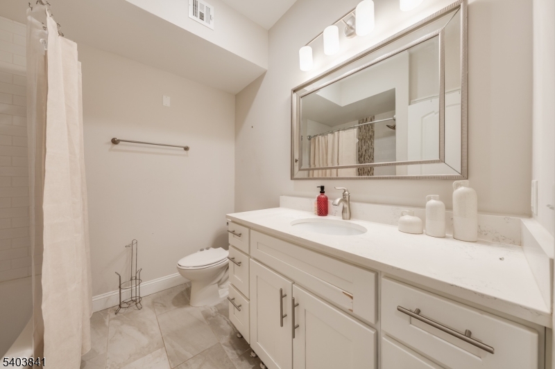 231 River Road, Unit 231 Somerville, NJ 08876 - Photo 24 of 31 a bathroom with a granite countertop sink vanity mirror and toilet