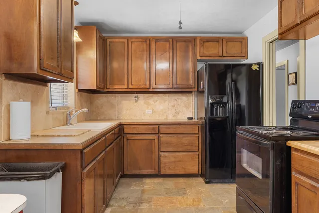 a kitchen with stainless steel appliances granite countertop a refrigerator stove and sink