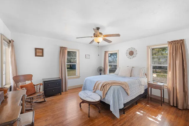 a bedroom with a bed and wooden floor