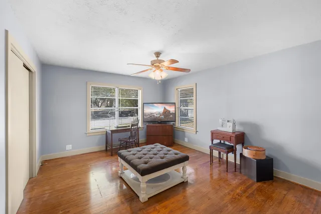 a living room with furniture and a dining table with wooden floor